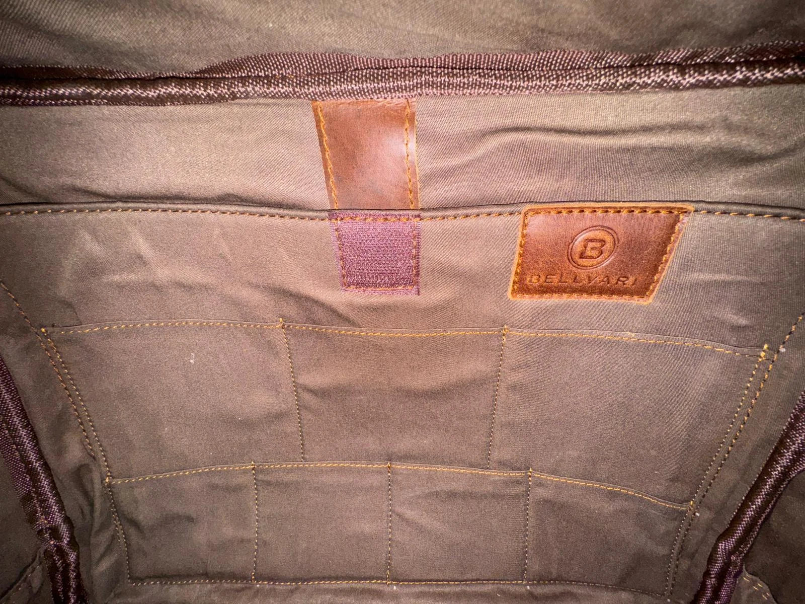 Real photo of the Crazy Horse Brown Messenger fabric pocket panel, with the retaining tab and Bellvari patch visible.