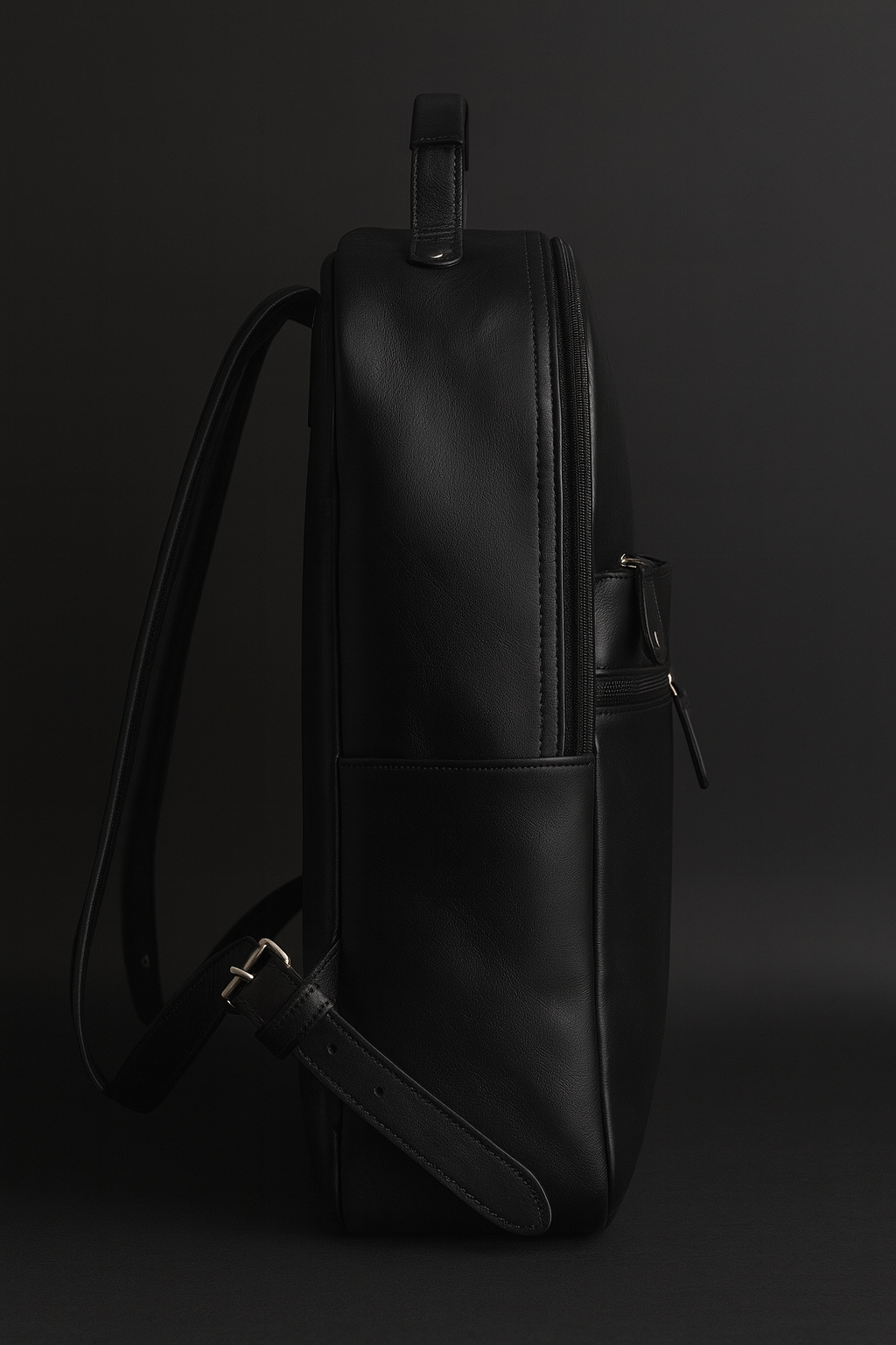 Black leather backpack on a dark background