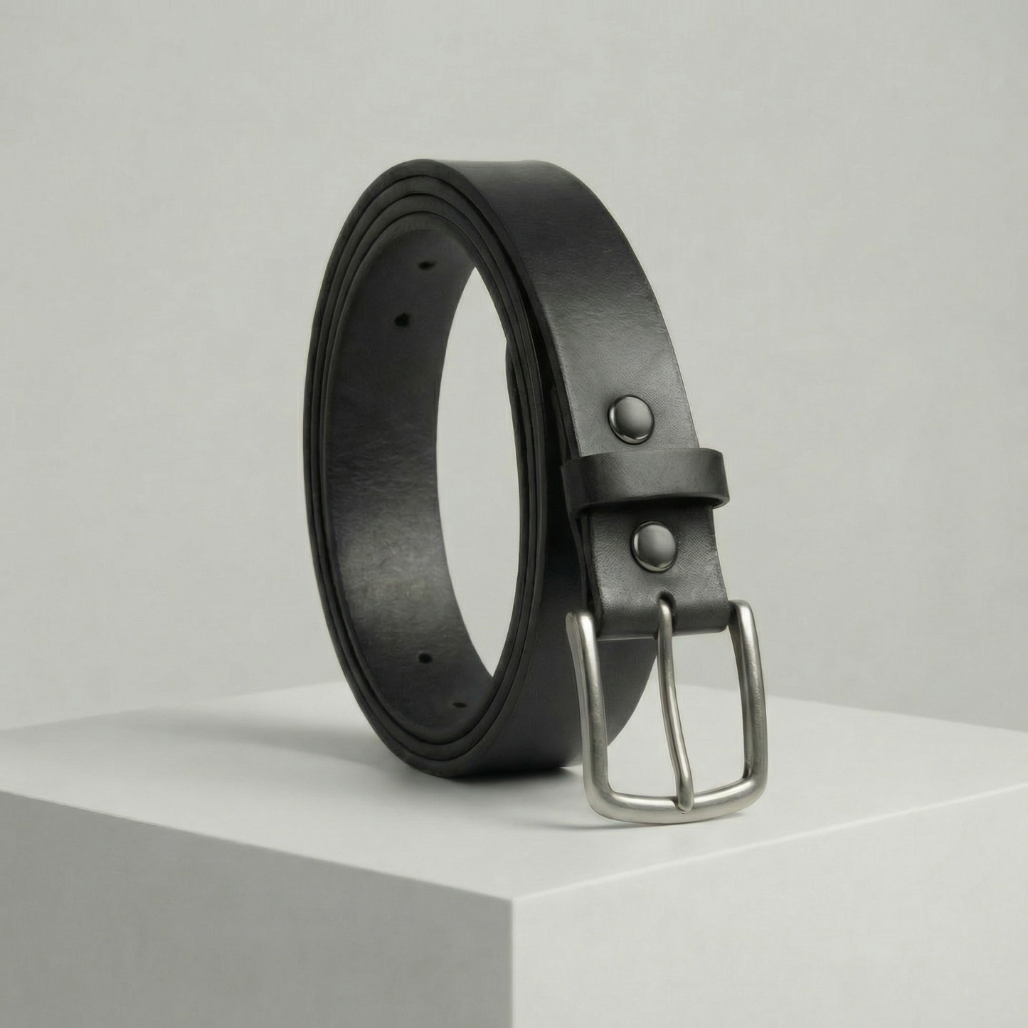 Bellvari Maverick jet-black full-grain leather belt with brushed steel buckle on a neutral background.