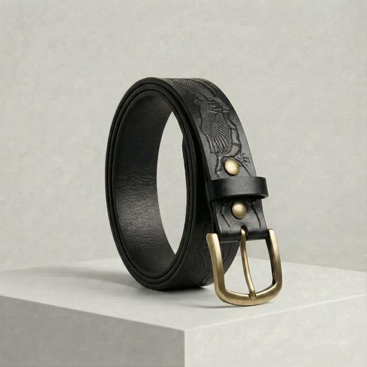 Bellvari Ironhide belt in black, hand-tooled Western pattern with antique-brass harness buckle and brass rivets.