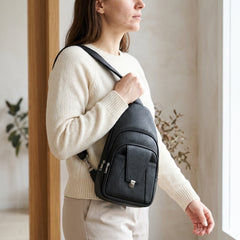 A woman wearing the black Bellvari Metro Sling across her chest. — view 12