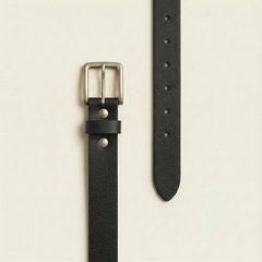 Bellvari Tradesman black full-grain leather belt laid flat, showing the pebbled grain, holes and brushed steel buckle. — view 2