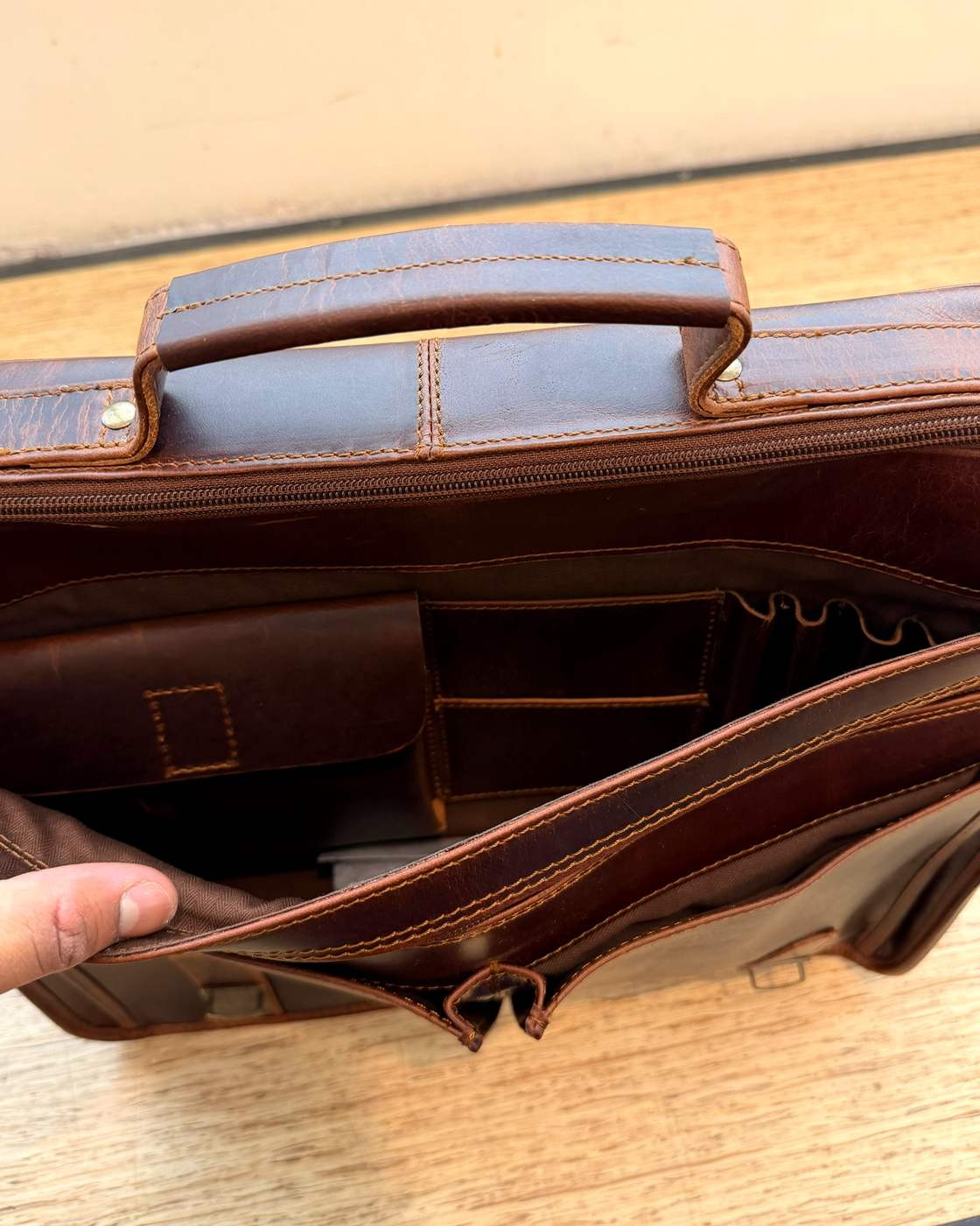 Real photo inside The Messenger showing the small leather pouch, stacked slip pockets and pen loops.